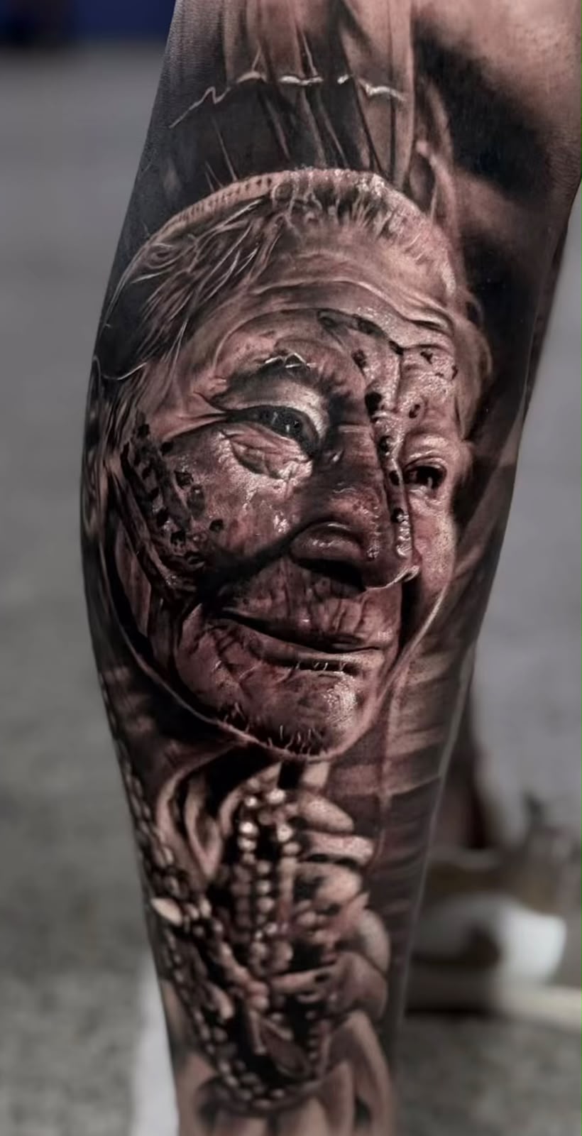 Tatuagem realista de face com textura detalhada em panturrilha