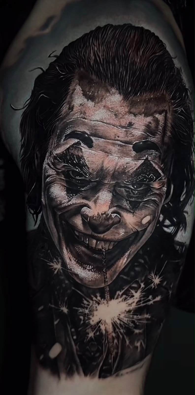 Tatuagem realista de coringa em braço com alto contraste